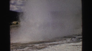 1967: people watching geiser in natural surroundings with sky and clouds WYOMING