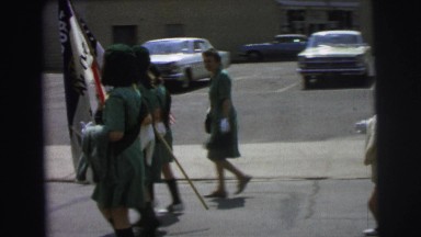 1972: old time girl scouts walking in parade with american flags LYNBROOK