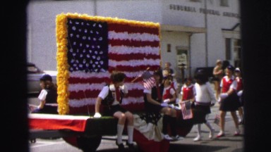 1972: kids marching in the parade show their u.s. pride and ride in on an