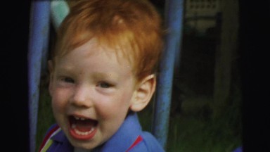 1972: two little boys in striped shirts ride on a playset LYNBROOK, NEW YORK