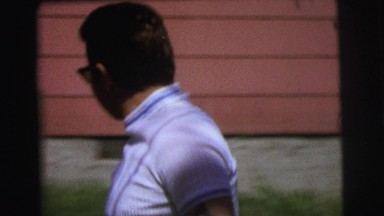 1972: Man in Sunglasses Walking and Children Climbing Fence in Lynbrook NY