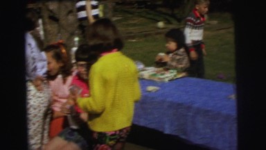 1972: group of children in a backyard enjoying cupcakes and playing around