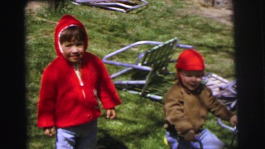 1972: children dressed for cool weather playing in the back yard LYNBROOK, NEW