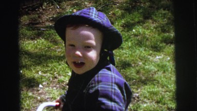 1972: a boy smiles in several settings while wearing various outfits and hats