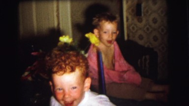 1972: two kids laugh at another one crawling on the floor LYNBROOK, NEW YORK
