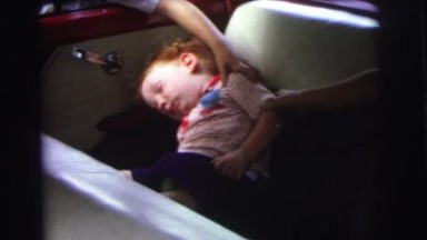 1972: a boy and a girl wake up a sleeping baby from the backseat