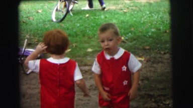 1972: two funny kids in similar dress is standing on the ground LYNBROOK