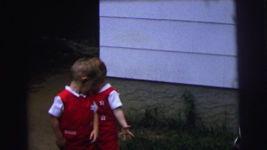 1972: an older boy and two cute small boys dressed in matching red outfits