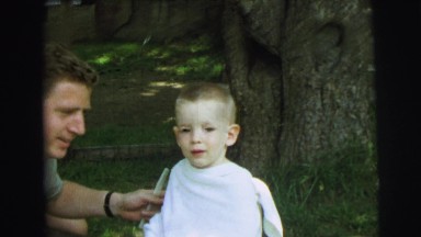 1972: child received buzzcut outside and father plays with son's hair LYNBROOK