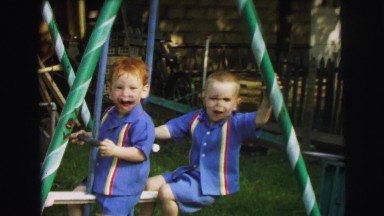 1972: two children posing for camera while playing on swing set LYNBROOK