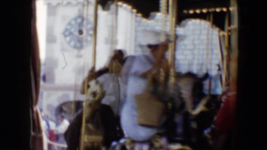 1959: Various People Riding a Traditional Amusement Park Merry-Go-Round at Disneyland