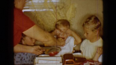 1959: parent calms a young unhappy child with a lollipop while several children