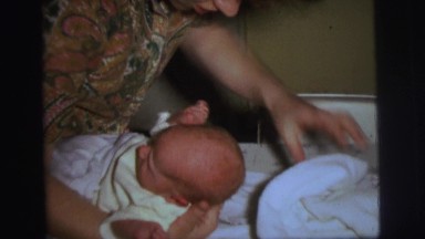 1972: newborn baby is lifted to put a white blanket under head LYNBROOK