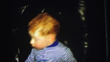 1972: cute little red headed boy rocking back and forth in a leather armchair