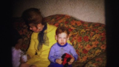 1972: redheaded boy sitting on couch with two ladies and baby LYNBROOK, NEW YORK