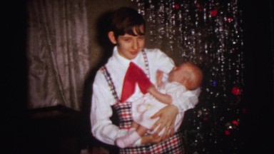 1972: man with a beautiful baby in his hand before a camera LYNBROOK, NEW YORK