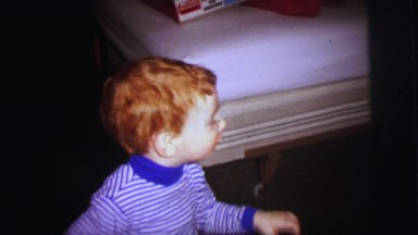 1972: a little boy riding for the first time his new bright red tricycle