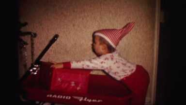 1972: boy playing in red wagon on christmas morning LYNBROOK, NEW YORK