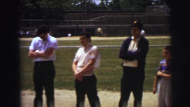 1972: people stand quietly near boy holding american flag while man speaks