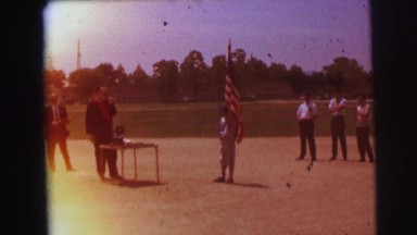 1972: young boy holds american flag on a short staff while a line of onlookers