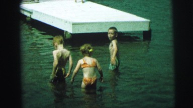 1972: a group of children in swimsuits having fun in the water