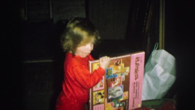 1972: several children open gifts accompanied by an adult woman