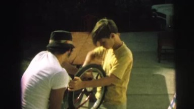 1972: a boy and his father repair a bicycle LYNBROOK, NEW YORK
