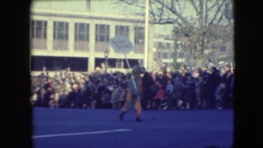 1948: youth carries a sign in a parade introducing "big ears the dope"