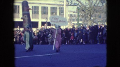 1948: two people parading in street wearing funky costumes