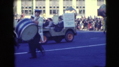 1948: people in various costumes marching through the street in a parade