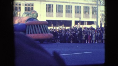1948: huge model moving through the street amid a large crowd watching
