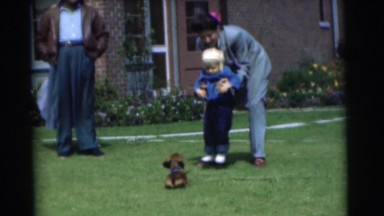 1951: there are 2 adults a child and a dog, the dog wants to play with the child
