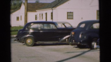 1951: a beautiful black car pulling out of a parking space