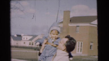 1951: father and baby enjoy their outdoor winter activity in the snow CHATHAM,