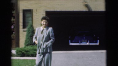 1951: woman walking in front of house CHATHAM, NEW JERSEY