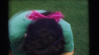 1951: a pretty woman in the yard straightening up her toddler's outfit CHATHAM,