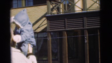 1951: man bounces and kisses baby in his arms before setting child down CHATHAM,