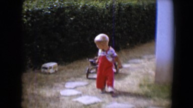 1958: a cute little boy in red overalls pulling a wagon behind him TUCSON,