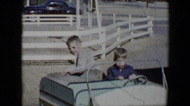 1958: boys riding in children's car with no one steering TUCSON, ARIZONA