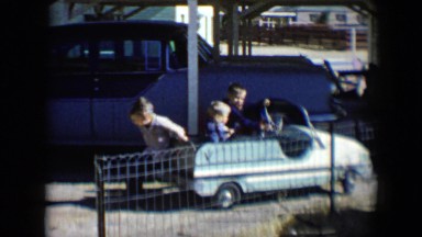 1958: child tries to push two friends in a toy car TUCSON, ARIZONA