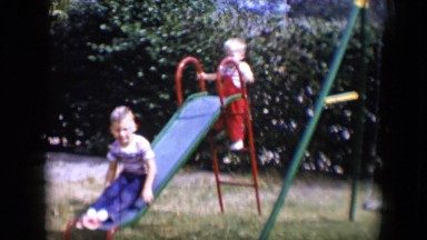 1958: small children having a great time sliding in backyard TUCSON, ARIZONA