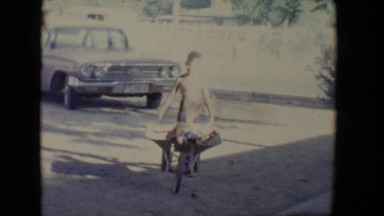 1958: two kids playing in a wheelbarrow in the front yard TUCSON, ARIZONA