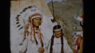 1958: three beautifully dress people in traditional american indian garb