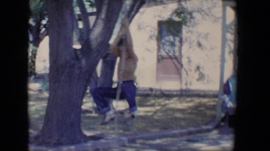 1958: boy ascends to top of rope hanging from tree and jumps to the ground