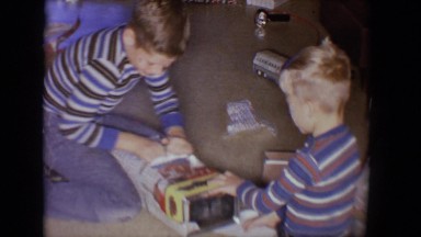 1958: two children unwrap present boy tries to open mom comes to help TUCSON,