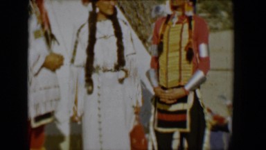 1958: three beautifully dress people in traditional american indian garb