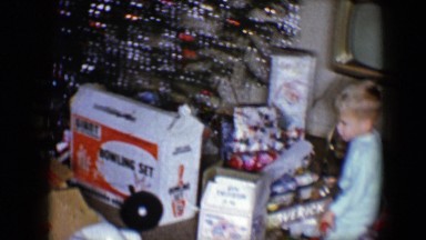 1959: child unwraps gift on christmas morning DISNEYLAND, CALIFORNIA