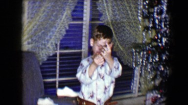 1959: two small boys in pajamas opening presents around a christmas tree