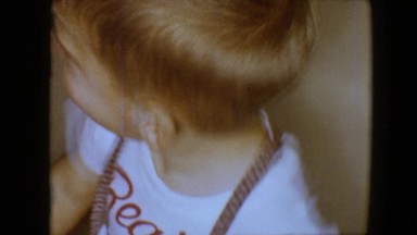 1959: two children are in a room and one of them jumps on a large sofa