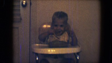 1959: boy in high chair eating and dumping food on the floor smiling DISNEYLAND,